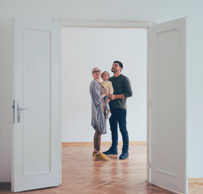 Una familia abrazada dentro de su casa.
